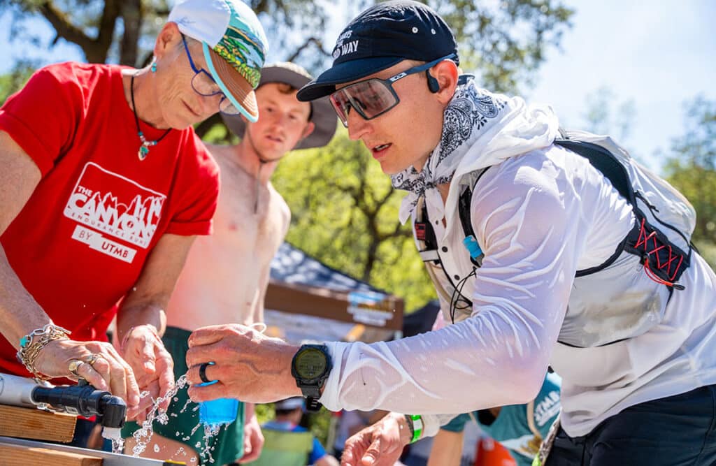 runner getting water at aid station