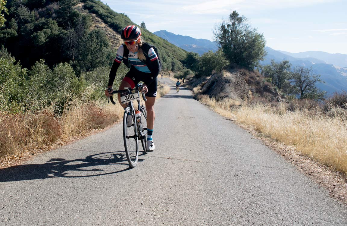 woman cyclist riding uphill