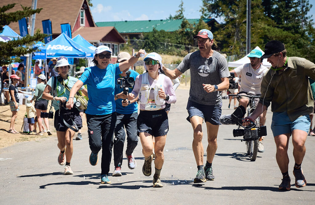 Fuzhao Xiang running through aid station at WSER25